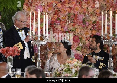 EXKLUSIV - König Carl Gustaf wird während des Hochzeitsessens im Königlichen Palast in Stockholm nach der Hochzeit von Prinz Carl Philip und Prinzessin Sofia in der Königlichen Kapelle am 13. Juni 2015 Sofia und Carl Philip anstoßen sehen. Stockfoto