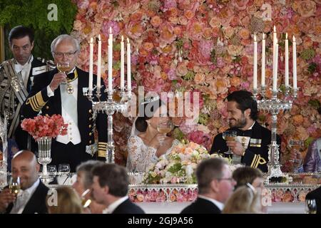 EXKLUSIV - König Carl Gustaf wird während des Hochzeitsessens im Königlichen Palast in Stockholm nach der Hochzeit von Prinz Carl Philip und Prinzessin Sofia in der Königlichen Kapelle am 13. Juni 2015 Sofia und Carl Philip anstoßen sehen. Stockfoto