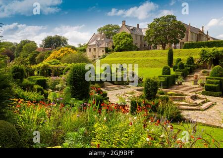 Die farbenfrohen Grenzen und das Topiary im italienischen Fountain Court Garten im Mapperton House, Dorset, England, Großbritannien Stockfoto