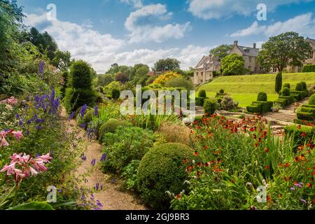 Die farbenfrohen Grenzen und das Topiary im italienischen Fountain Court Garten im Mapperton House, Dorset, England, Großbritannien Stockfoto