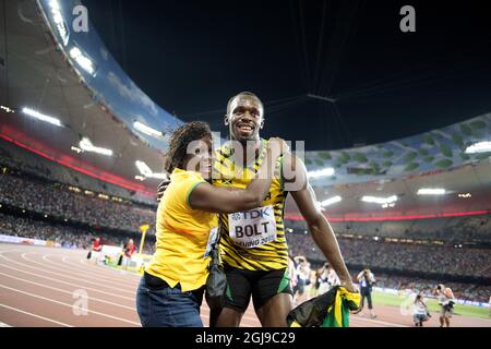 PEKING 20150823 Usain Bolt aus Jamaika wird von seiner Mutter Jennifer Bolt umarmt, nachdem er das 100-m-Finale der Männer während der IAAF-Weltmeisterschaft 2015 in Peking im Nationalstadion in Peking, China, am 23. August 2015 gewonnen hat. Foto: Jessica Gow / TT / Kod 10070 Stockfoto