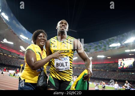 PEKING 20150823 Usain Bolt aus Jamaika wird von seiner Mutter Jennifer Bolt umarmt, nachdem er das 100-m-Finale der Männer während der IAAF-Weltmeisterschaft 2015 in Peking im Nationalstadion in Peking, China, am 23. August 2015 gewonnen hat. Foto: Jessica Gow / TT / Kod 10070 Stockfoto