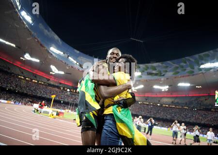 PEKING 20150823 Usain Bolt aus Jamaika wird von seiner Mutter Jennifer Bolt umarmt, nachdem er das 100-m-Finale der Männer während der IAAF-Weltmeisterschaft 2015 in Peking im Nationalstadion in Peking, China, am 23. August 2015 gewonnen hat. Foto: Jessica Gow / TT / Kod 10070 Stockfoto