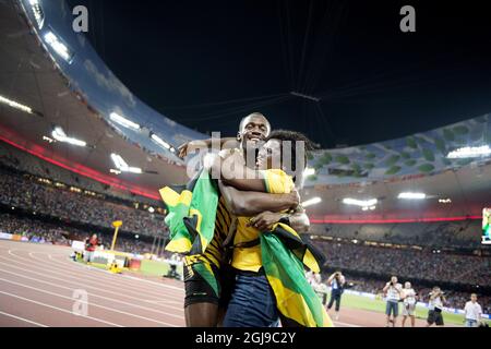 PEKING 20150823 Usain Bolt aus Jamaika wird von seiner Mutter Jennifer Bolt umarmt, nachdem er das 100-m-Finale der Männer während der IAAF-Weltmeisterschaft 2015 in Peking im Nationalstadion in Peking, China, am 23. August 2015 gewonnen hat. Foto: Jessica Gow / TT / Kod 10070 Stockfoto