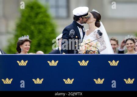 STOCKHOLM, SCHWEDEN 20150613. Hochzeit zwischen Prinz Carl Philip und Sofia Hellqvist. Die frisch verheiratete Braut und Bräutigam Prinz Carl Philip und Prinzessin Sofia küssen sich während der samstags geäußerten Prinzenhochzeit vor der Menge vor dem Königspalast in Stockholm. Hintergrund: Königin Silvia (links) und Kronprinzessin Victoria (rechts). Foto: Jon Olav Nesvold / NTB scanpix Stockfoto