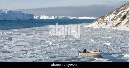 Fischer fischen im Fjord. Winter am Ilulissat Fjord, der in der Disko Bay in Westgrönland liegt, ist der Fjord Teil des UNESCO-Welterbes Stockfoto