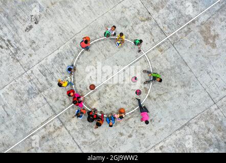 (210909) -- ZHENYUAN, 9. September 2021 (Xinhua) -- Luftfoto vom 8. September 2021 zeigt Studenten, die Spiele auf dem Spielplatz am Pingyu-Lehrpunkt des Dorfes Songbai, Gemeinde Baojing im Bezirk Zhenyuan, südwestlich der Provinz Guizhou, spielen. Der Pingyu-Lehrort liegt tief in der Bergregion des Bezirks Zhenyuan, der autonomen Präfektur Qiandongnan Miao und Dong, südwestlich der Provinz Guizhou, und wird hauptsächlich von einem Paar unterstützt. Im Jahr 2000 schloss Pan Zhongyong eine normale Schule ab und kam als Lehrer an die Pingyu-Lehrstelle. Später traf er Zhu Muqun, ein Mädchen in t Stockfoto