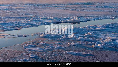 Morgendämmerung an der gefrorenen Disko Bay im Winter, Westgrönland, Disko Island im Hintergrund. Grönland, Dänemark Stockfoto