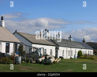 Eine Reihe von traditionellen weiß getünchten Steinhütten, ehemalige Häuser der Steinbrucharbeiter auf Easdale, einer der Slate Islands in den Inner Hebrides. Stockfoto