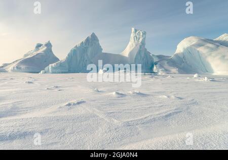 Eisberg wurde im Meereis der Melville Bay in der Nähe von Kullorsuaq im hohen Norden von Westgrönland eingefroren. Stockfoto