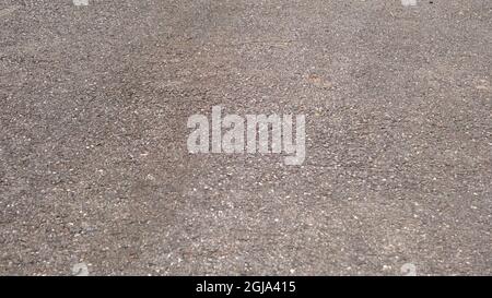 Riss auf grauen Asphalt Textur Hintergrund. Straßenbau und Design-Konzept. Verschlissener schlechter Asphalt Stockfoto