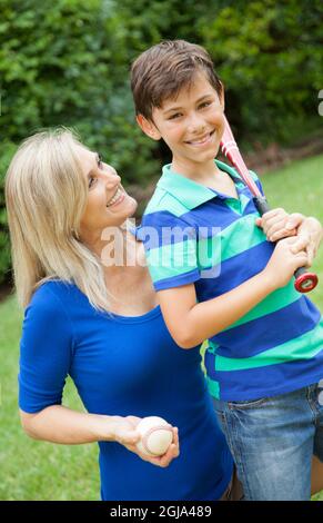 Mutter und Sohn spielen im Hof (MR) Baseballspiele. Stockfoto