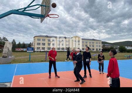 (210909) -- HARBIN, 9. September 2021 (Xinhua) -- Foto, das am 6. September 2021 mit einem Mobiltelefon aufgenommen wurde, zeigt Ma Jianguo beim Basketballspielen mit Studenten an der Beiji Zentralschule im Dorf Beiji der Stadt Mohe, nordöstlich der Provinz Heilongjiang in China. MA Jianguo ist der Direktor der Beiji Zentralschule im Dorf Beiji, auch bekannt als das arktische Dorf. Im Jahr 1997 kam Ma nach Mohe und wurde nach seinem Universitätsabschluss Dorflehrer. Als er zum ersten Mal hierher kam, fehlte es der Schule an Lehrern. So hat Ma seitdem verschiedene Fächer unterrichtet. Im Laufe der Jahre haben viele Lehrer die Schule verlassen, BU Stockfoto