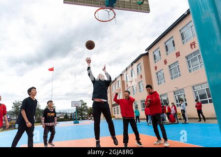 (210909) -- HARBIN, 9. September 2021 (Xinhua) -- Ma Jianguo spielt Basketball mit Studenten an der Peji Zentralschule im Dorf Beiji der Stadt Mohe, nordöstlich der Provinz Heilongjiang, 6. September 2021. MA Jianguo ist der Direktor der Beiji Zentralschule im Dorf Beiji, auch bekannt als das arktische Dorf. Im Jahr 1997 kam Ma nach Mohe und wurde nach seinem Universitätsabschluss Dorflehrer. Als er zum ersten Mal hierher kam, fehlte es der Schule an Lehrern. So hat Ma seitdem verschiedene Fächer unterrichtet. Im Laufe der Jahre haben viele Lehrer die Schule verlassen, aber Ma blieb, weil er Underprivi glaubte Stockfoto