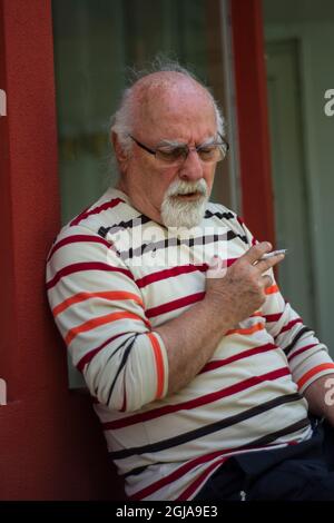 Rentner alter Mann, der raucht und hustet. Ein ungesundes Leben. Stockfoto