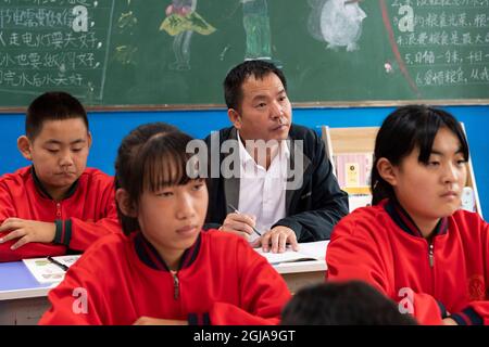 (210909) -- HARBIN, 9. September 2021 (Xinhua) -- Ma Jianguo nimmt mit Studenten an der Peji Zentralschule im Dorf Beiji der Stadt Mohe, nordöstlich der Provinz Heilongjiang, am 6. September 2021 Teil. MA Jianguo ist der Direktor der Beiji Zentralschule im Dorf Beiji, auch bekannt als das arktische Dorf. Im Jahr 1997 kam Ma nach Mohe und wurde nach seinem Universitätsabschluss Dorflehrer. Als er zum ersten Mal hierher kam, fehlte es der Schule an Lehrern. So hat Ma seitdem verschiedene Fächer unterrichtet. Im Laufe der Jahre haben viele Lehrer die Schule verlassen, aber Ma blieb, weil er unterprivilegierte glaubte Stockfoto