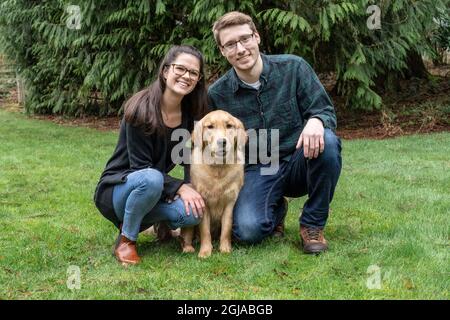 Issaquah, Staat Washington, USA. Porträt einer neun Monate alten Golden Retriever mit ihren Besitzern. (PR, MR) Stockfoto