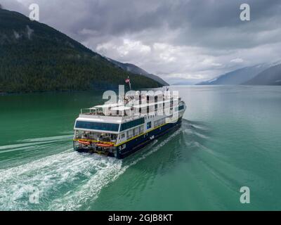 USA, Alaska, Tracy Arm-Fords Terror Wilderness, Luftaufnahme des Kreuzfahrtschiffs National Geographic Quest, das am Sommernachmittag in Endicott Arm fuhr (Edi Stockfoto