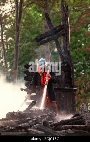 Die 23-jährige Dame, die die Kirchen in Frogn und Saner angezündet hatte, erklärte sich schuldig, als der Fall begann. Feuermänner halten hier mit Aussterben des Feuers in der Frogn Kirche Stockfoto