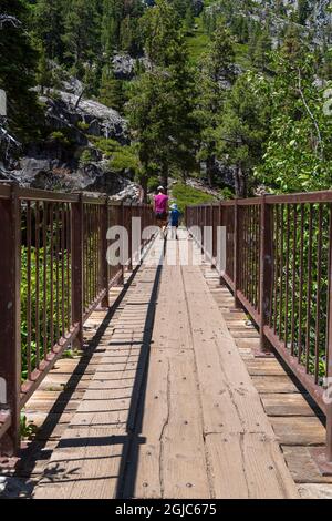 Mutter und Kind gehen über die Brücke entlang des Eagle Lake Trail, Lake Tahoe, Kalifornien. Stockfoto