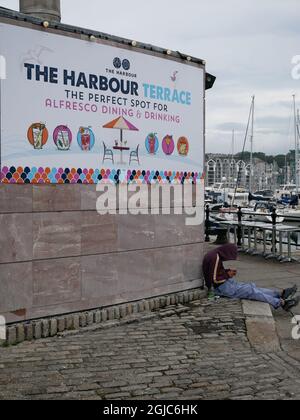 Hospitality Worker macht eine Pause im Restaurantbereich Harbour Terrace, Barbican, Sutton Harbour Marina, Plymout, Devon UK Stockfoto