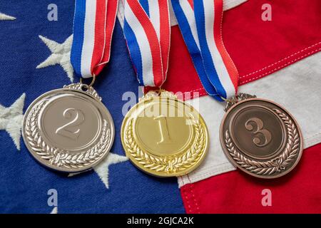 Medaillen-Set, US-Flagge. Gold, Silber und Bronze auf amerikanischem Symbol. Gewinner, US-Athleten Podium Preis Trophäe Konzept. Stockfoto