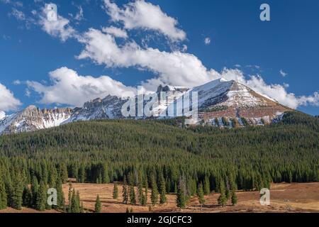 USA, Colorado, Uncompahgre National Forest, Cumulus Wolken im Herbst über San Miguel Mountain (links), Sheep Mountain und immergrünen Wald. Stockfoto