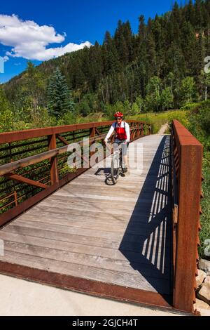 Mountainbiker über eine Brücke auf dem Galopp Goose Trail, Uncompahgre National Forest, Colorado, USA. (MR) Stockfoto