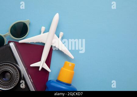 Ansicht von oben mit einem Spielzeug-Flugzeug auf blauem Hintergrund von wichtigen Urlaubsartikeln Stockfoto