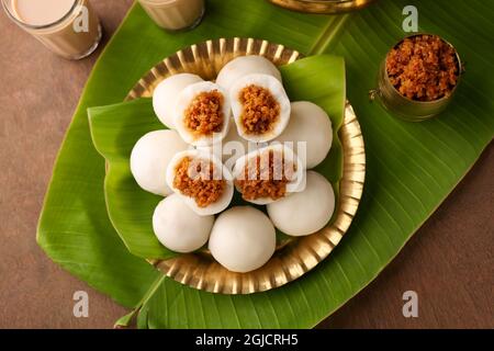 Kozhukatta Pidi in goldenen Teller Indian Kerala Tee Zeit Snack gedämpfte Lebensmittel süß Modak Reis Knödel ganesha chathurthi, Diwali, Navratri Dussehra Stockfoto