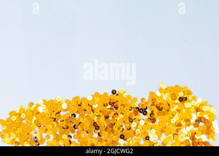 Hellblauer Hintergrund mit goldenem Konfetti, selektiver Fokus Stockfoto