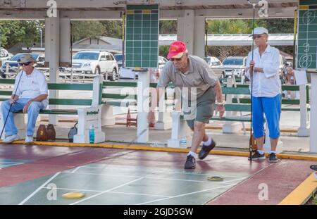 Senioren spielen ein wettbewerbsfähiges Shuffleboard-Spiel in der Flager Ave in New Smyrna Beach, Florida. Stockfoto