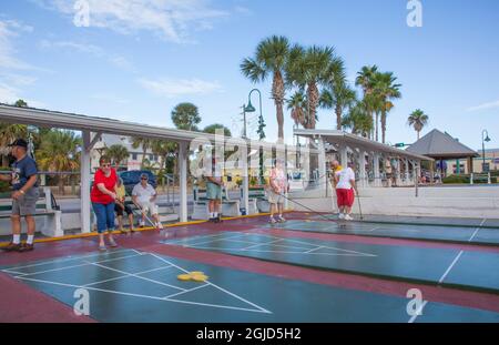 Senioren spielen ein wettbewerbsfähiges Shuffleboard-Spiel in der Flager Ave in New Smyrna Beach, Florida. Stockfoto