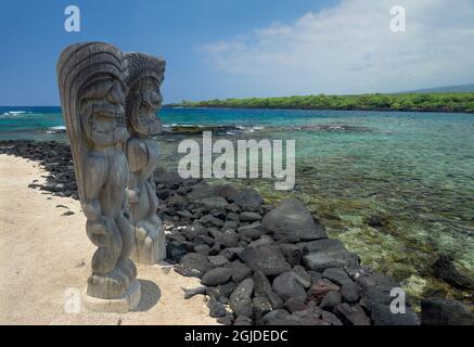 USA, Hawaii, Big Island of Hawaii. PU'uhonua O Honaunau National Historical Park, geschnitzte Holzstatuen namens KI'i und Keone'ele Cove. Stockfoto