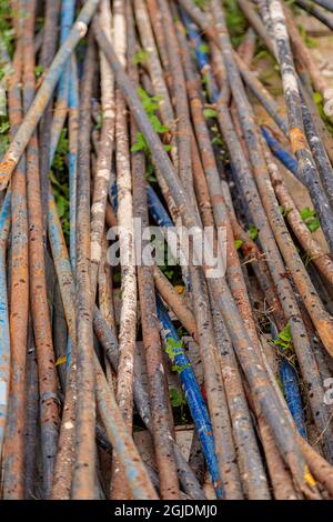 Ein Haufen rostiger Stahlrohre auf dem Boden. Rostige Montagerohre auf einer Baustelle. Stockfoto