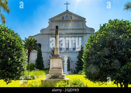 Sonnenstrahlen Garten Jesus Statue hinten, Saint Louis Kathedrale älteste Kathedrale Fassade, New Orleans, Louisiana. Erbaut 1718 Louis König von Frankreich Stockfoto