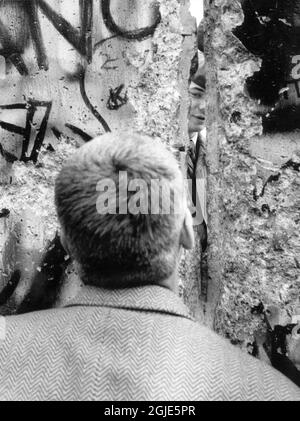 Berlin 1989-11-15 der Fall der Berliner Mauer, die Grenzöffnung. Ein Mann, der durch einen Riss in der Wand schaut. Foto: Sven-Erik Sjoberg / DN / TT / Code 53 Stockfoto