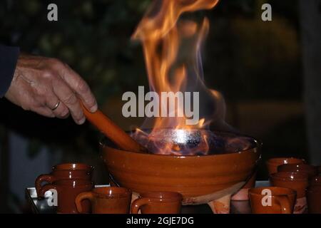 Männliche hand Vorbereitung a Queimada, traditionelle galizische alkoholische Heißgetränk. Stockfoto