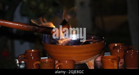 Männliche hand Vorbereitung a Queimada, traditionelle galizische alkoholische Heißgetränk. Stockfoto