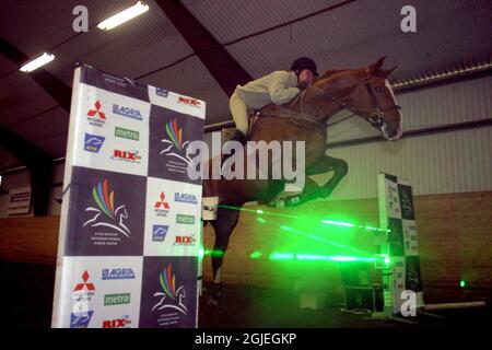 Helena Persson aus Schweden testet die Laserstrahl-Hindernisse in der Djursholm Arena. Die Laserhindernisse werden im Laufe des Jahres zum ersten Mal auf der Stockholm International Horse Show eingesetzt. Stockfoto