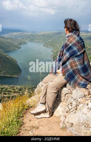 Frau, Frau, Tourist mit Blick über den Parque Nacional de Monfrague und den Fluss Tajo von El Castillo de Monfrague. Extremadura, Spanien. Stockfoto