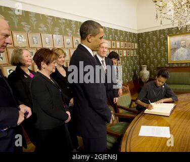 US-Präsident Barack Obama sieht zu, wie First Lady Michelle Obama das Gästebuch am Nobel Institute in Oslo, Norwegen, unterschreibt Stockfoto