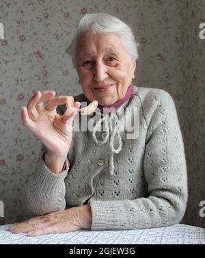 Die flexiblen Nylonprothesen in älteren weiblichen Händen. Zahnmedizinisches Konzept Stockfoto