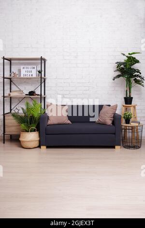 Moderne Einrichtung mit Sofa, Tisch und Regal - kopieren Platz über Backsteinwand und Boden Stockfoto