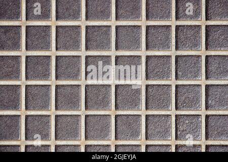 Geprägte alte Metallbodenstruktur, Oberfläche in einem Käfig. Rostiger Metallboden, Industrieböden. Nahaufnahme. Selektiver Fokus. Speicherplatz kopieren. Stockfoto