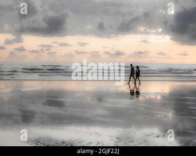 USA, Oregon, Cannon Beach und eine traumhafte Aussicht auf den Strand bei Ebbe, wenn ein Paar vorbei geht. Stockfoto