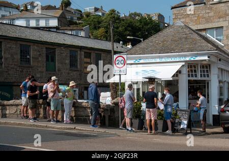 Newlyn, Cornwall, England, Großbritannien. 2021. Die Kunden stehen Schlange, um mittags in Newlyn, Cornwall, Großbritannien, ein Fischrestaurant zu betreten Stockfoto