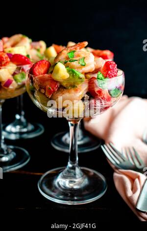 Erdbeer-Garnelen-Ceviche-Cocktails in Coupé-Gläsern: Garnelensalat in einer Champagneruntertasse im Cocktailstil Stockfoto
