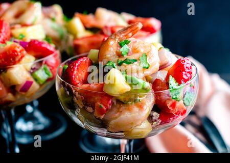 Erdbeer-Garnelen-Ceviche-Cocktails in Coupé-Gläsern: Garnelensalat in einer Champagneruntertasse im Cocktailstil Stockfoto