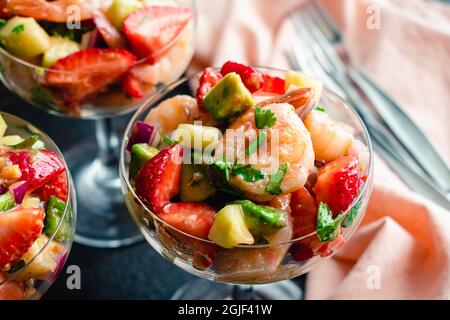 Erdbeer-Garnelen-Ceviche-Cocktails in Coupé-Gläsern: Garnelensalat in einer Champagneruntertasse im Cocktailstil Stockfoto